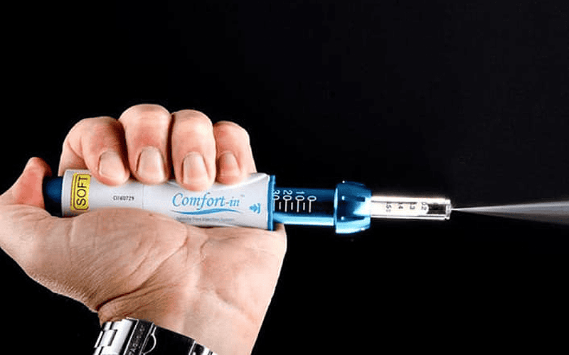 Hand holding a syringe with needle, promoting injection-free anesthesia for hair treatments.